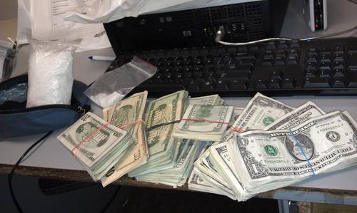 Bags of drugs next to a large sum of cash
