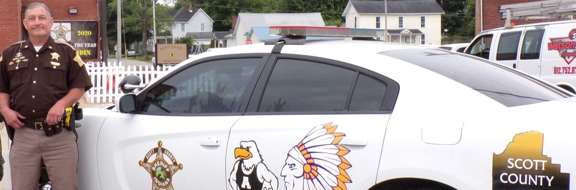 Sheriff Jerry Goodin next to a Scott County patrol vehicle.